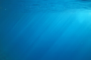 ocean underwater rays of light background, under blue water sunlight