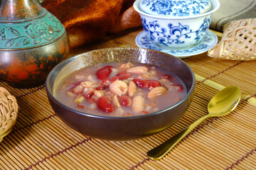 Chinese traditional mixed rice congee in glass bowl. Rice congee made with red beans, lotus seeds, longan, red dates, and nuts. Sweet congee, Selective focus