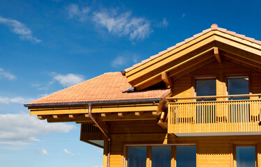 Neubau Holzhaus aus Massivholz im alpinen Stil nach traditioneller Art mit Dachgaube und Balkon