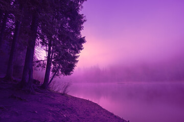 Vroege mistige ochtend. Zonsopgang boven het meer. Geschilderd in fluweel paars