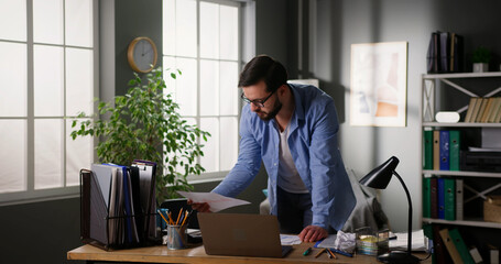 Depressed man feeling worried about financial problems, doing paperwork. Stressed businessman...