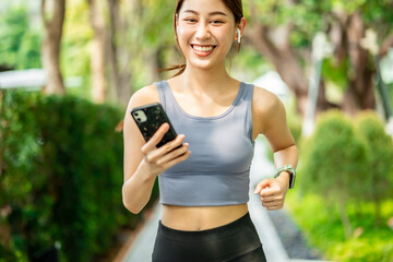 Running Asian woman. Female Runner Jogging during Outdoor Workout in a Park. Asian woman running in garden. Her morning exercise.Young Asian Girl doing yoga in the park