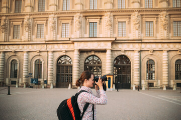 Fototapeta na wymiar Stockholm, Sweden. Young Adult Caucasian Woman Lady Tourist Traveler Photographer Taking Pictures Photos Near Stockholm Palace. Royal Palace In Old Town Gamla Stan. Famous Popular Place. UNESCO