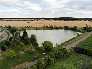 Obraz premium Photos of nature from a height. We see a field, a bike path and a heart-shaped pond.
