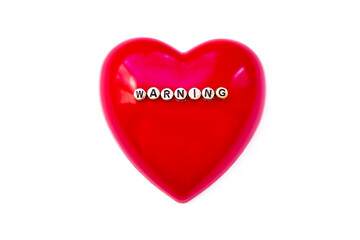 Warning word on red heart. White background.