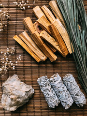 incense on a bamboo brown stand close-up, palo santo from Peru and California white sage, dried...