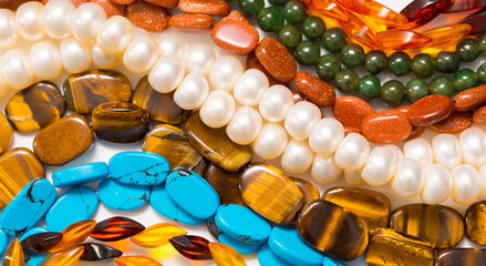 Beads and necklaces made of colored semi precious stones. Background from a variety of beautiful...