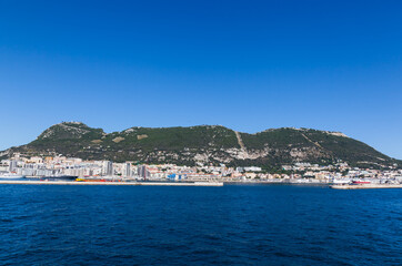 Fototapeta premium View from the sea to the port of Gibraltar. Bay, buildings, moored ships and yachts and the mountain.