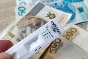 Coronavirus rapid antigen test with polish PLN banknotes. Corona virus SARS-Cov-2 fast negative test. test cassette on several euro banknotes background