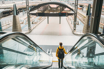 Oslo, Norway. Young Adult Caucasian Woman Visiting Oslo Central Station Railway Station. Woman Backpacker Tourist Goes Down To Trains Platform On Escalator. Travel Concept. - obrazy, fototapety, plakaty