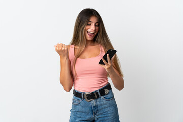 Young caucasian woman isolated on white background with phone in victory position