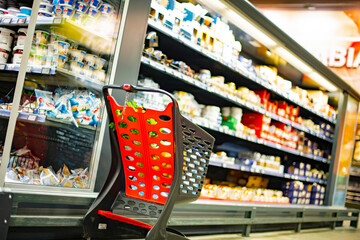 A shopping cart with grocery products in a supermarket