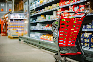 A shopping cart with grocery products in a supermarket