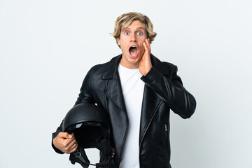 English man holding a motorcycle helmet with surprise and shocked facial expression