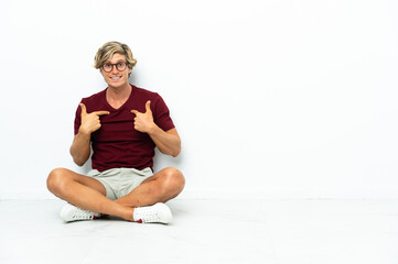 Fototapeta premium Young English man sitting on the floor with surprise facial expression