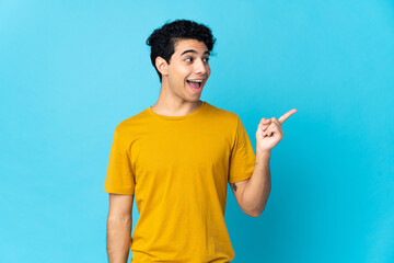 Young Venezuelan man isolated on blue background intending to realizes the solution while lifting a finger up