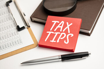 Magnifying Glass with TAX TIPS on the paper sheet and pen