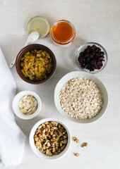 Natural and healthy ingredients for making energy bars at home. Products lie in different bowls on a light background. Healthy food concept. Top view.