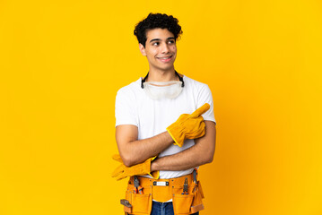 Venezuelan electrician man isolated on yellow background pointing up a great idea