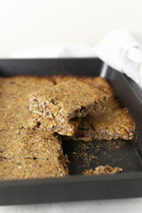 Cooked and cut into pieces energy bars in a casserole dish. Healthy food concept. Copy space. Vertical orientation.