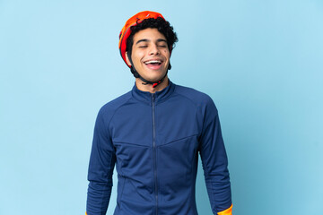 Venezuelan cyclist man isolated on blue background laughing