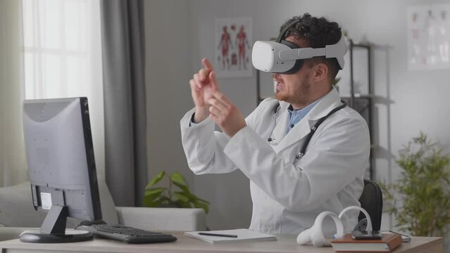 Man doctor holding a video conference while sitting in the office in vk glasses
