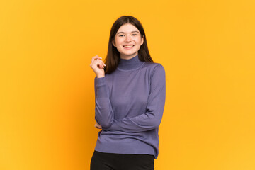 Young Ukrainian girl isolated on yellow background laughing