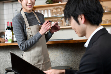 カフェ（飲食店）で働くアジア人の女性の店員（注文・オーダー）