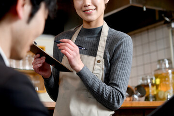 カフェ（飲食店）で働くアジア人の女性の店員（注文・オーダー）