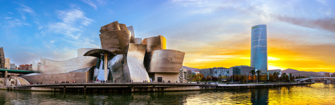 Bilbao, Spain - NOV 20, 2021: awesome evening panoramic view of The Guggenheim Museum designed by Frank Gehry and embankment Estuary of Bilbao and skyscraper of energy company IBERDROLA