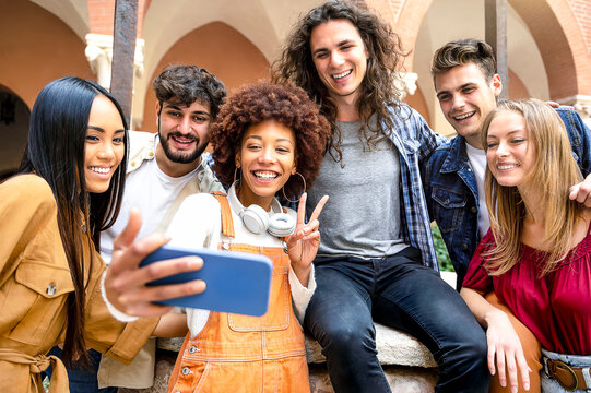Multiracial group of students taking photos with smartphone camera - Selfie of young smiling friends having fun together - Happy friendship concept with teenagers people having fun together