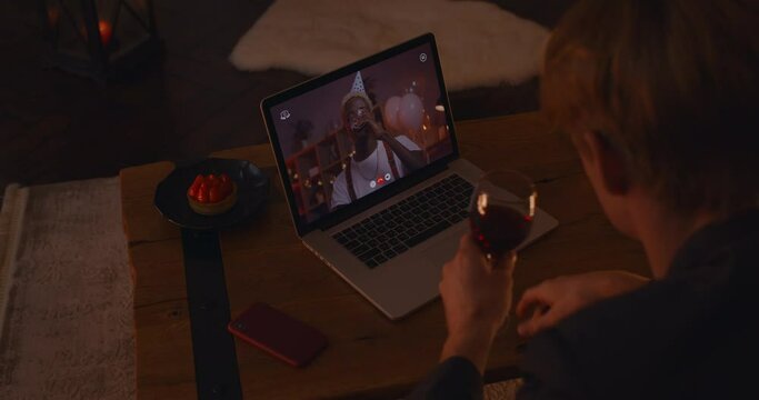 Two gays drinking wine and chatting during video call