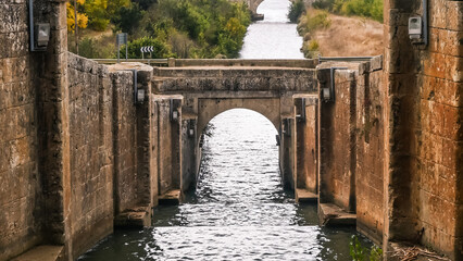 the river flows along artificial levels among the stone tunnel under the bridge