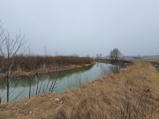 Gorin river in winter without snow on a foggy day