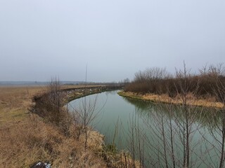 Gorin river in winter without snow on a foggy day