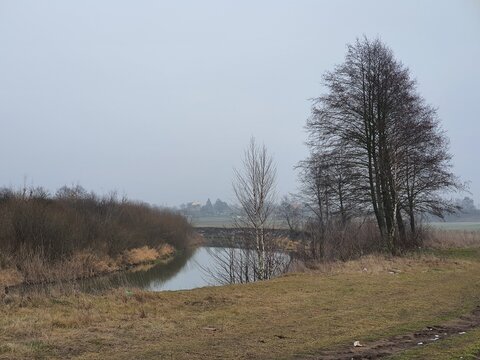 Gorin river in winter without snow on a foggy day