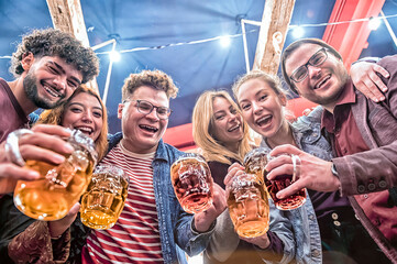 Group of happy friends enjoying, laughing and toasting beer at brewery bar restaurant - Happy...