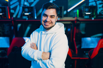 Young guy businessman entrepreneur owner gamer staying smiling on computer game club background. © primipil