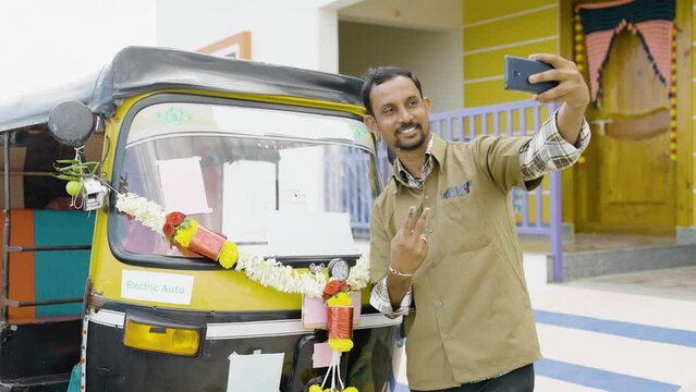 Auto driver taking selfie with his auto rickshaw to post on social media about new business - concept of self employment and transportation service