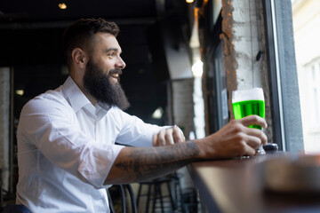 Happy man sitting in a bar for the St. Patrick's Day