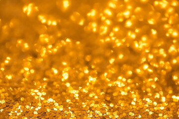 Blurred festive golden background. Bokeh background of yellow Christmas sparkles. Beautiful Christmas decoration of the interior of the house.