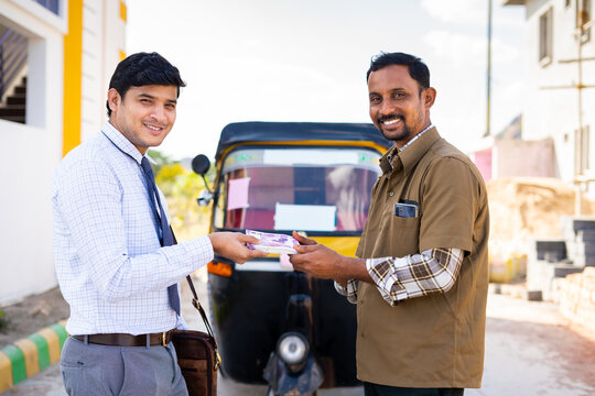 Young Indian Auto Rikshaw Driver Reciving Loan Money From Banker In Front Of Tuk Tuk By Looking At Camera - Concept Of Banking Assistance, Approval Of Vehicle Loan And Support For Self Employment.