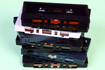 Stack of old vintage retro audio cassette tapes isolated on a green background