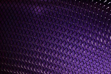 Macro close up view of a woven metalic stainless steel purple background
