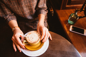 a cup of coffee and a woman's hands
