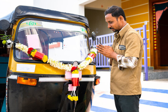 driver doing puja by offering incense to his new auto rickshaw before driving - concept of beliefs, rituals, start of new transportation business