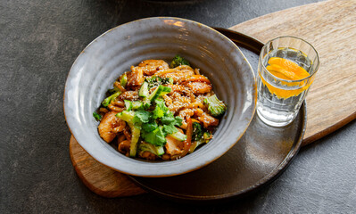 A bowl of udon with chicken and broccoli