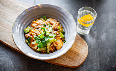 A bowl of udon with chicken and broccoli