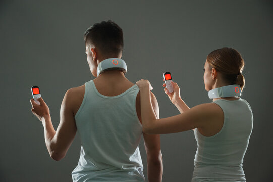 People Operate The Neck Massager Using A Remote Control.