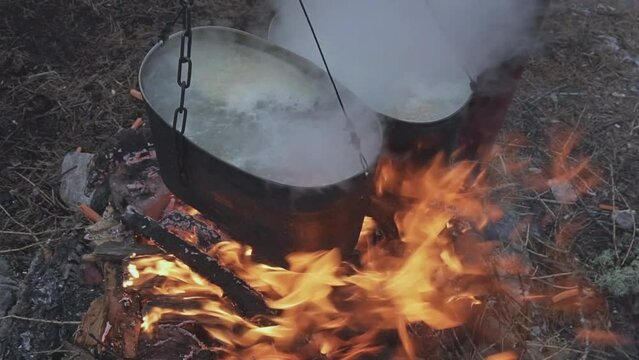 Bonfire with two cauldrons for cooking in the camp. Kindle Fire